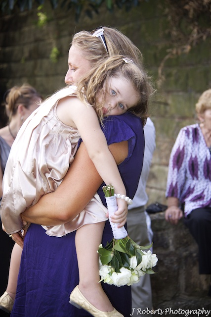 Flower girl in mothers arms - wedding photography
